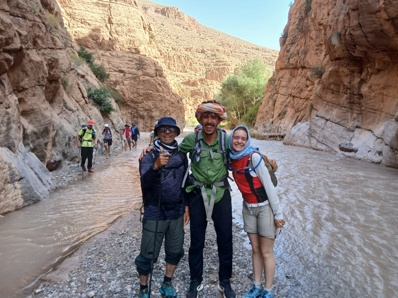 Panorama of Nangma Valley campsite with river flowing by backed by huge craggy mountains with snow